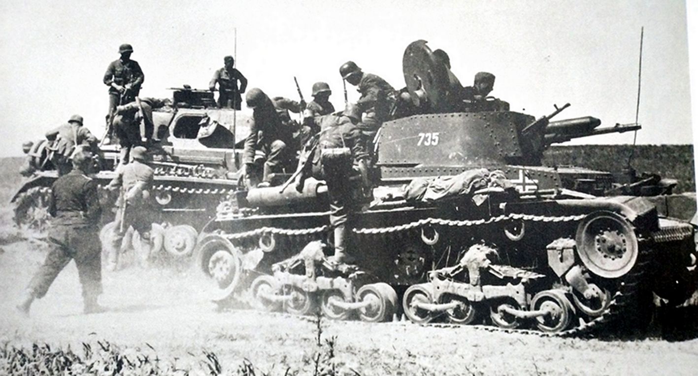 德军一辆35(t)坦克(前)和一辆Ⅳ号坦克(后)搭乘步兵到达战场,士兵正在下车。