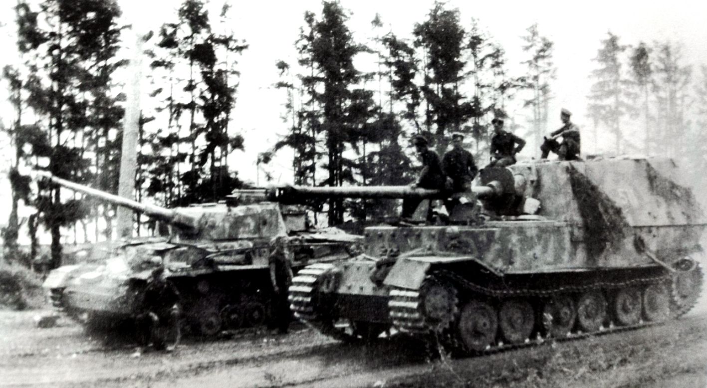 1943年7月苏联库尔斯克战场，德军654重装甲歼击营1连511号「费迪南德」坦克歼击车修复后正准备重返前线。该车左侧前挡板已被地雷炸飞，旁边是一辆受损的Ⅳ号坦克（隶属德军第35装甲团）。