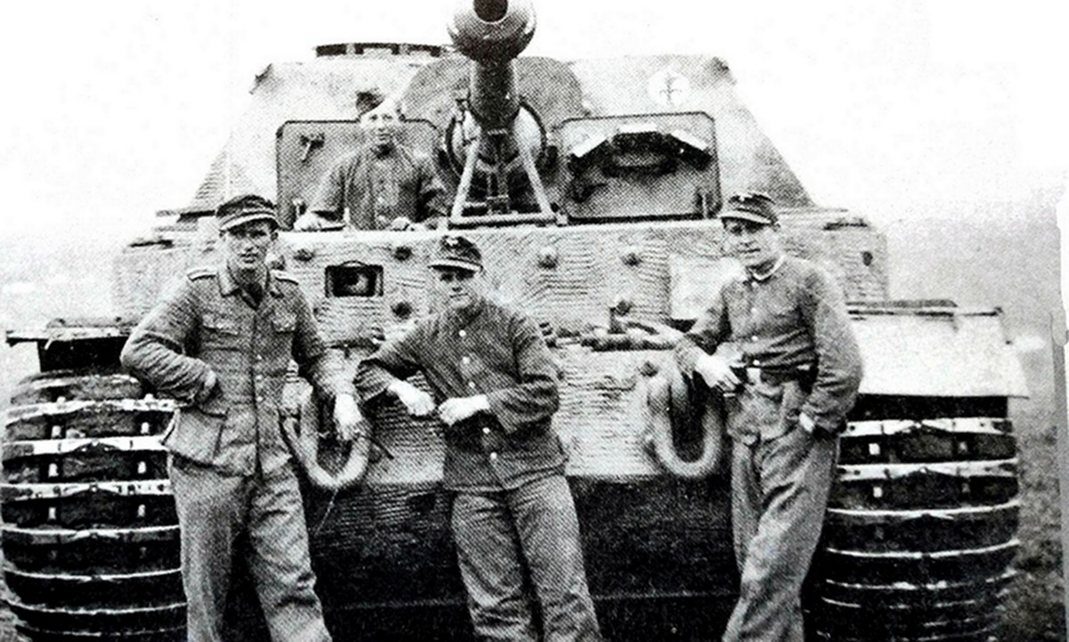 1944年初，吸取库尔斯克失败的教训，德军为剩余的「费迪南德」坦克歼击车装上了2挺MG34机枪，车改名「象」式，并陆续分配给653等重装甲歼击营，图中为653重装甲歼击营第3连的一辆「象」式坦克歼击车与车组乘员。车体上可清楚见到为车身所加的防磁涂层。