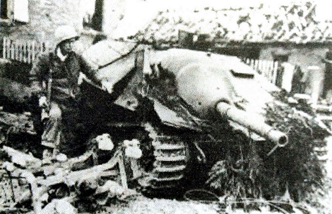 1945年，西线战场，一辆被击毁的德军「追猎者」坦克歼击车，一名美军正在车旁观察该车。