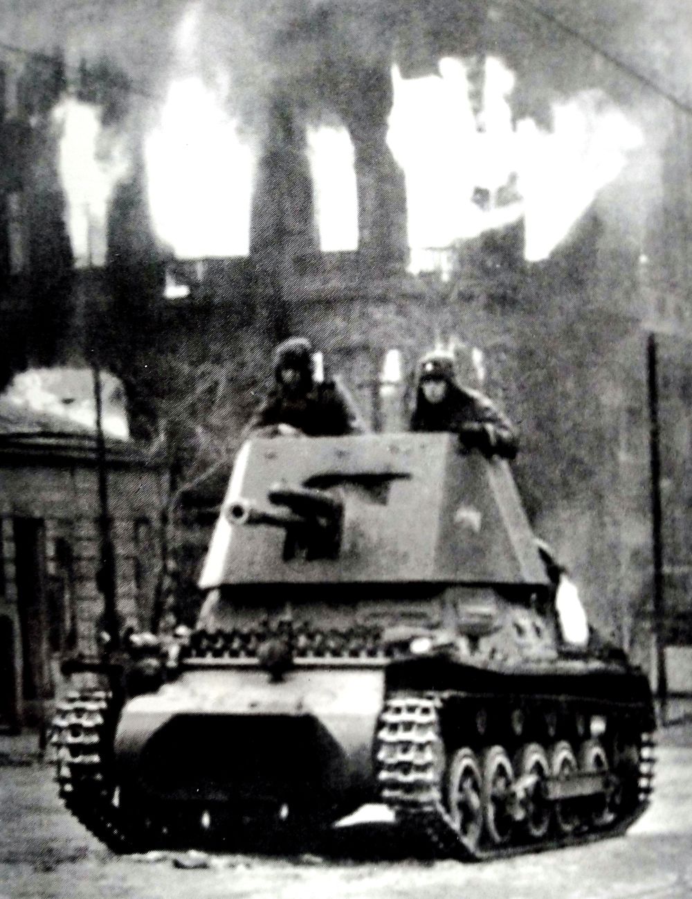 1942年3月，在苏联列宁格勒战场，一辆在战斗中行进的德军Ⅰ号47mm自行反坦克炮车。建筑物正在燃烧的熊熊大火表明该地区刚受过大规模的轰炸。时值苏联初春，炮车的乘员戴着大毡帽以抵御寒冷。