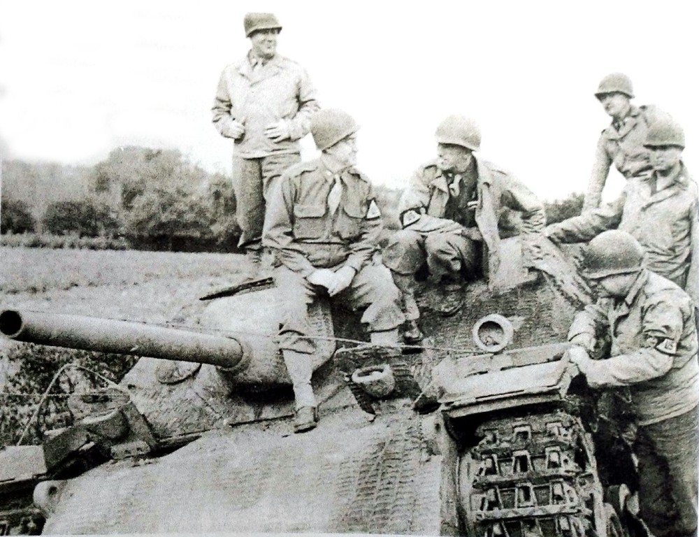 1944年在法国诺曼第战场，一些美军官兵围坐在一辆被击毁的德军L/48 Ⅳ号坦克歼击车上，显然，此时德军的反登陆作战已告失败。