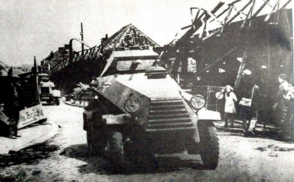 1940年5月，西线法国战场，一辆德军第7装甲师的Sd.Kfz.231型6轮装甲侦察车正穿过一座已攻占的法国城镇。