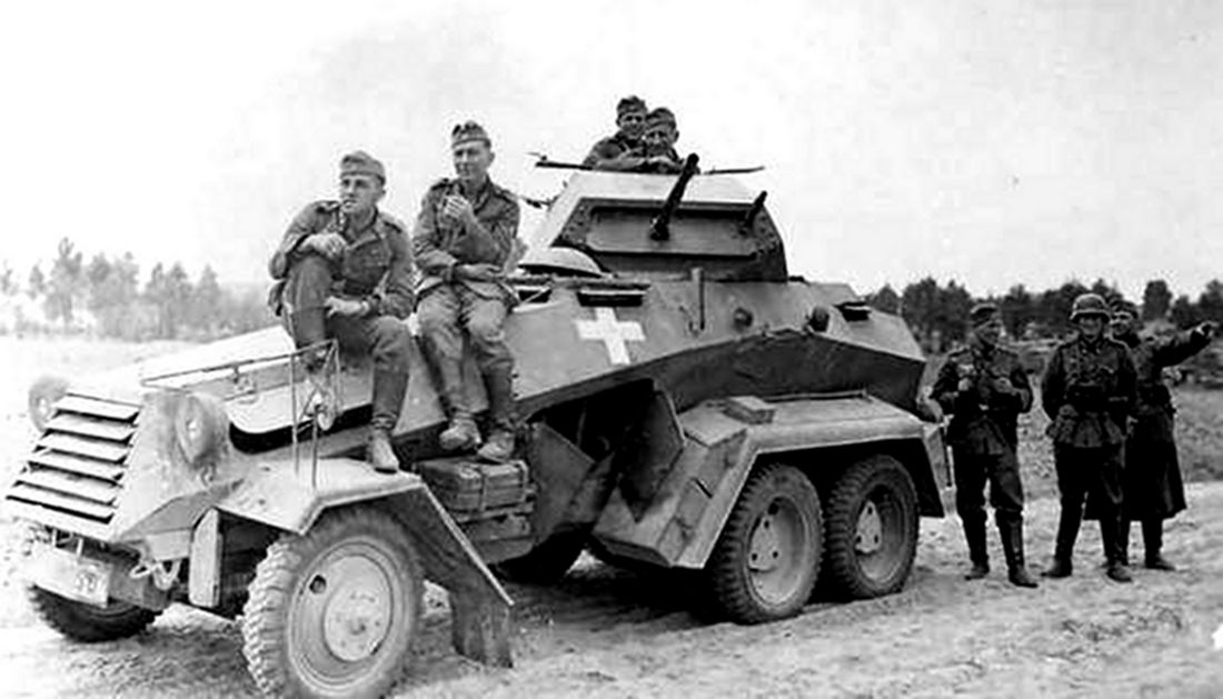 一群德军官兵与一辆Sd.Kfz.231型6轮装甲侦察车及乘员的合照。