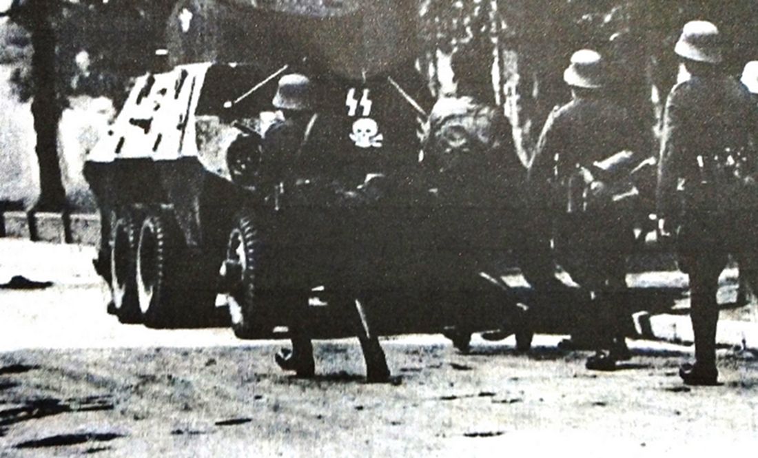 1939年9月，德军入侵波兰，在但格斯克城中作战的德国党卫队警察部队的一辆ADGZ型8轮重型装甲车正掩护士兵沿着街道向邮政大厦前进。注意车后印有党卫军与骷髅的标志。注：德国武装党卫军第3「骷髅」装甲师在波兰战役后成立，此党卫队警察部队后来也成为该师的一部分。
