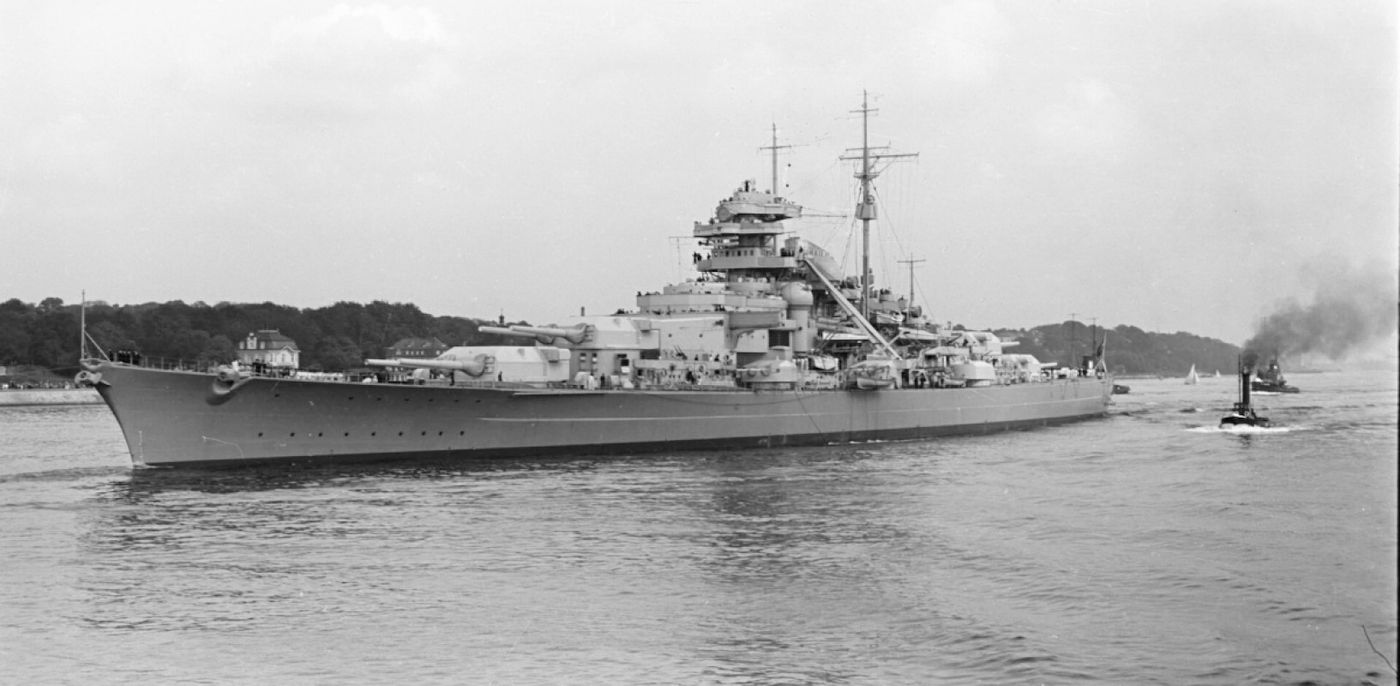 1941年5月24日「丹麦海峡海战」中,俾斯麦号主炮齐射,炮口喷出烈焰与浓烟。此次交战中,俾斯麦号击沉英国战列巡洋舰「胡德」号并重创「威尔士亲王」号,创下惊人战绩,却也因舰首中弹漏油而暴露了行踪。