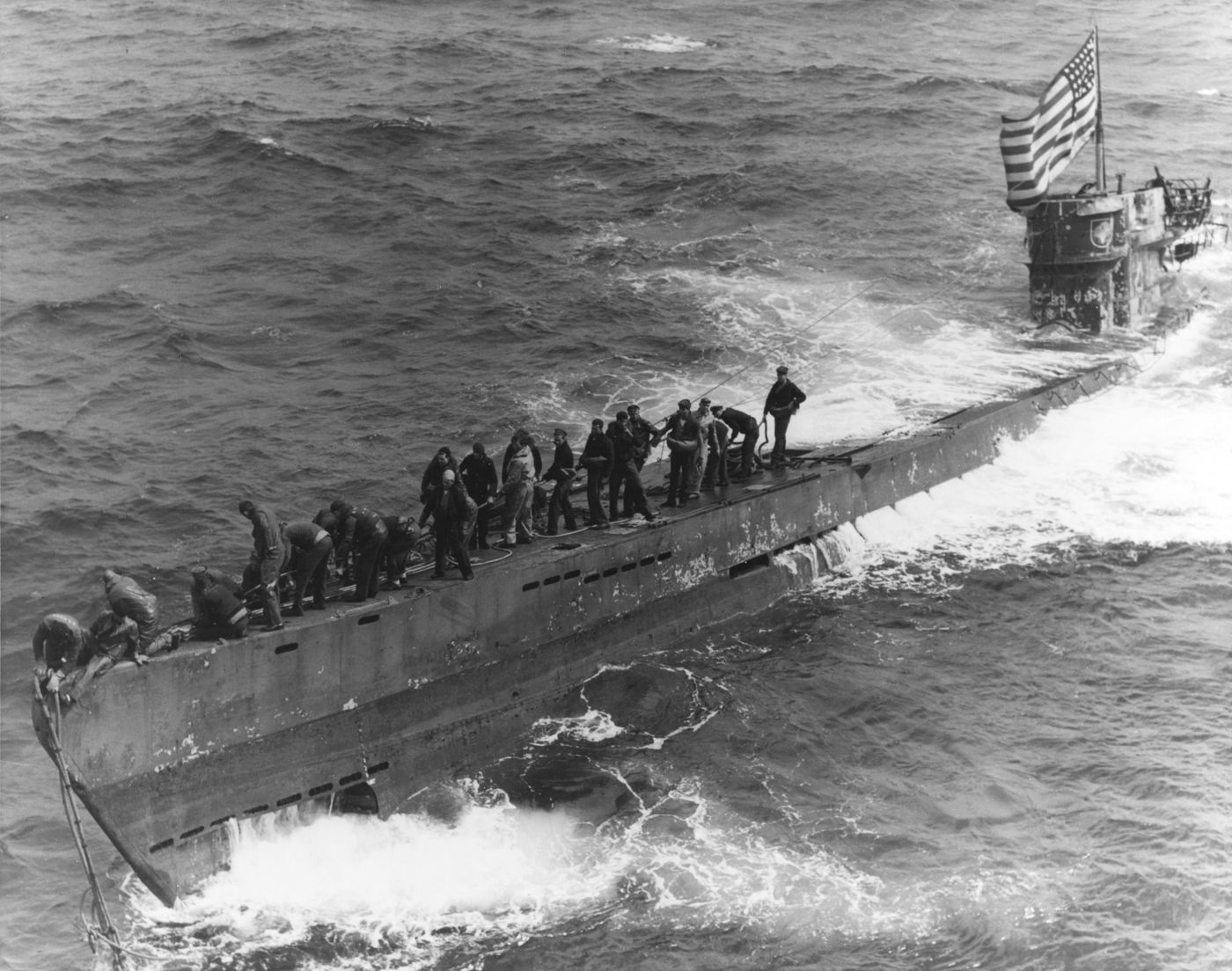 1944年6月4日，「大西洋战役」中，美国海军「皮尔斯伯里」号护航驱逐舰的登舰小组正在为被俘获的德国IXC型潜艇U-505号系挂拖缆，潜望镜上飘着美国国旗。这是1815年以来美军首次在公海俘获敌方军舰。