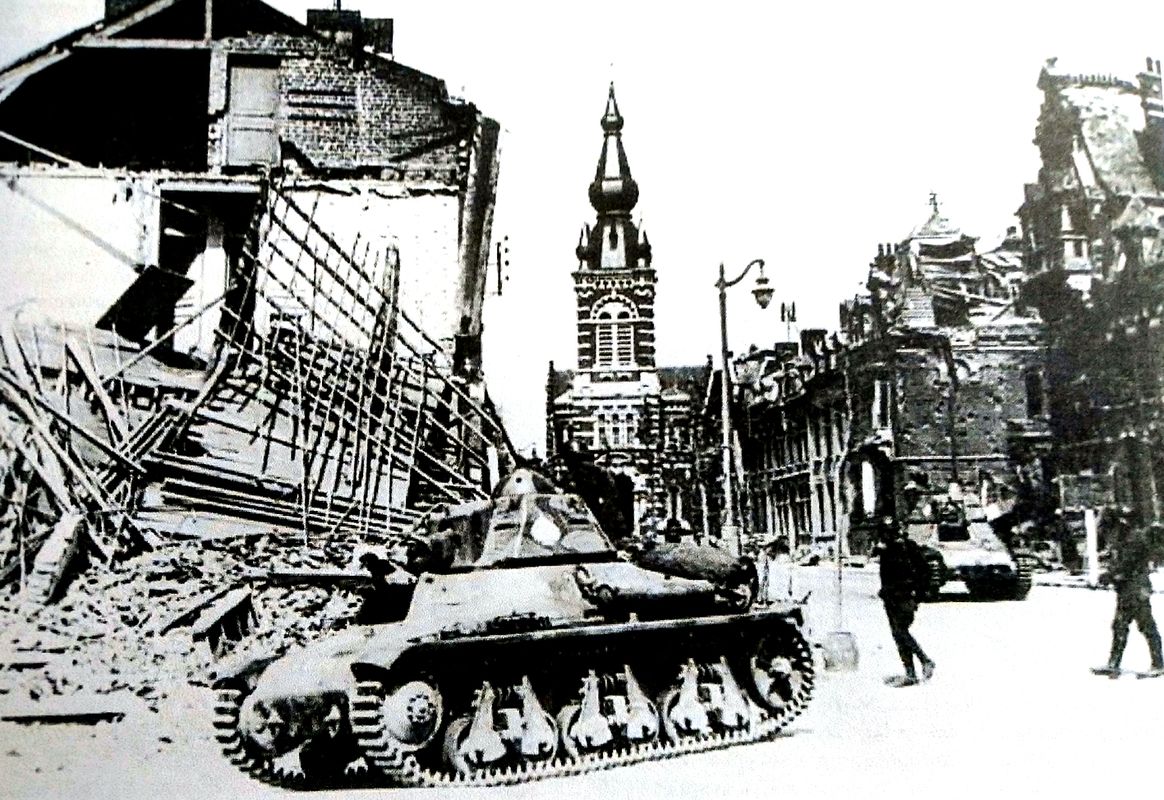 1940年5月，「法国战役」期间，比利时境内，两辆法军霍奇基斯H-35轻型坦克驶过一座被德军轰炸过的小镇。