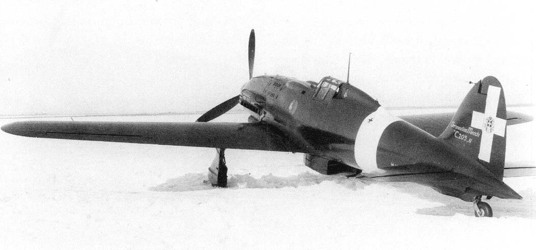 马基C.205N-1「猎户座」原型机(M.M.499)在雪地机场的三四前侧视角照片,机身为意大利三色圆形机徽,尾翼白色识别带与萨伏依十字清晰可见。C.205N采用全新机体与加大机翼,以提高高空性能。