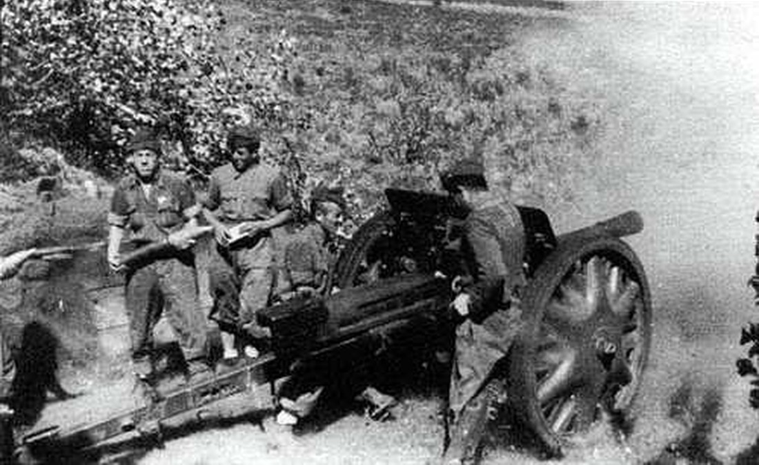 正在开火的1937年款75/32反坦克炮。注意:跑组成员正在搬运弹药,准备进行下一次射击。