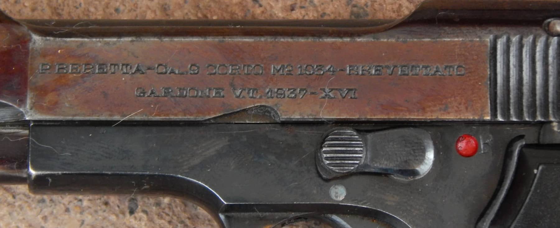 接上图：该枪套筒侧面刻有「P. Beretta - Cal.9 Corto Mo.1934-Brevettato Gardone V.T. 1937-XVI」字样，其中「Cal.9 Corto」意为9毫米短弹（即.380 ACP），而罗马数字「XVI」（16）则代表该年份是意大利法西斯统治的第16个年头。