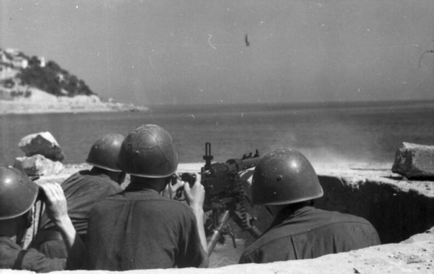 二战期间,意大利士兵在沿海防御阵地操作菲亚特-列维利M1935重机枪执行射击任务。