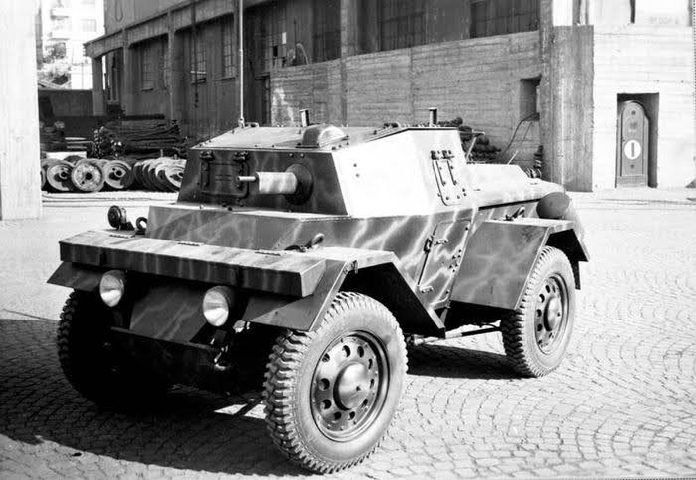 位于塞斯特里波南特 (Sestri Ponente) 的 Ansaldo-Fossati 工厂外，一辆刚刚出厂的 Autoblinda Lancia Lince 轻型轮式装甲车。该型车虽然也使用了 Autoblinda 的前缀，但它并非是由 AB 系列装甲车发展而来，而是因1941年意军缴获了英军的「野狗」装甲车（Daimler Dingo）后，对其紧凑轻便、机动灵活的设计印象深刻，从而由蓝旗亚仿制出 Autoblinda Lancia Lince （意大利语「山猫」）。