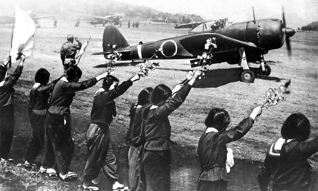 1945年4月12日，一群日本女学生向一架挂载250公斤（550磅）炸弹、即将执行神风特攻任务的一式战斗机「隼」（Ki-43 IIIa型）战斗机挥手告别。