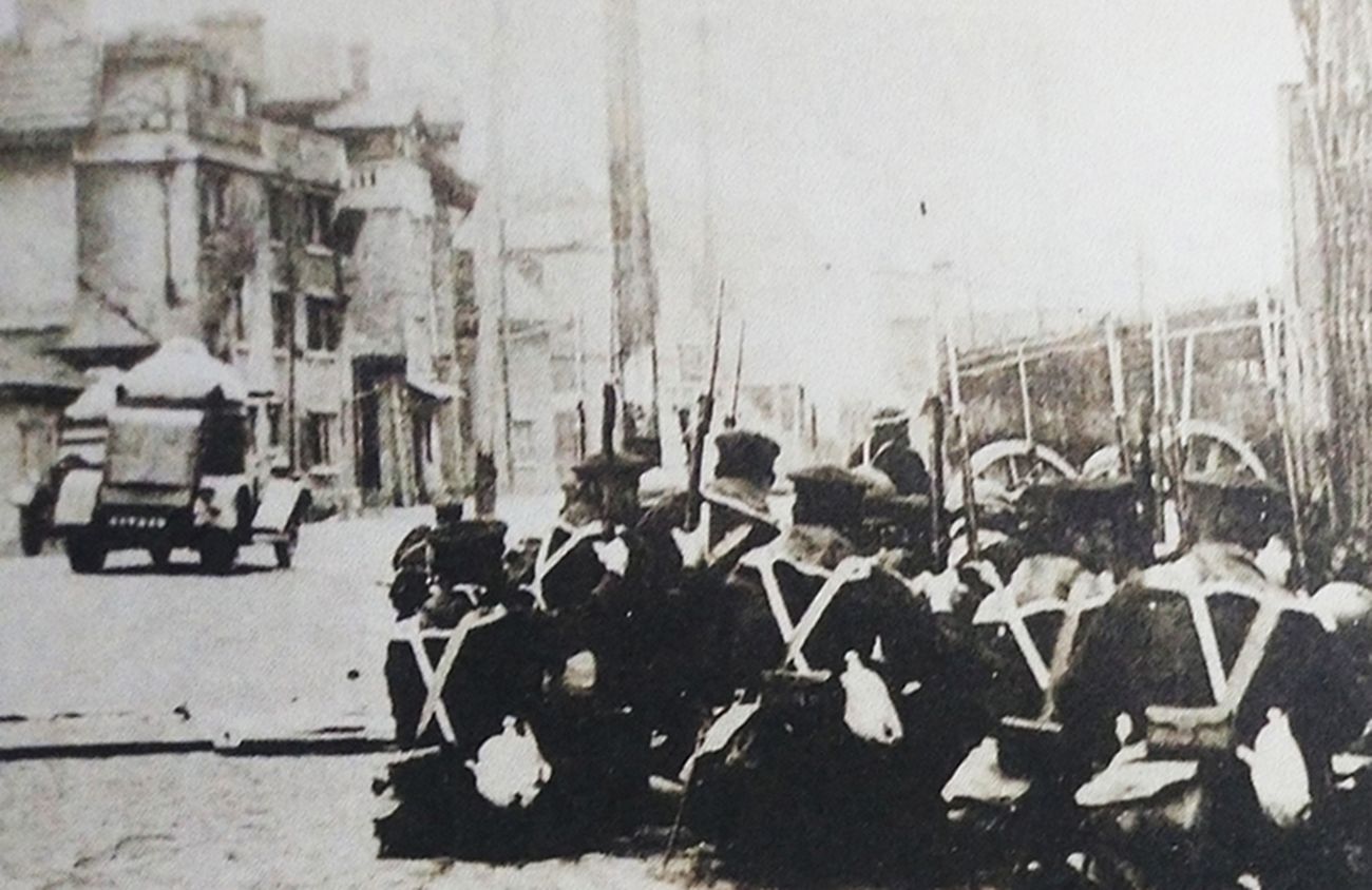 1932年,上海一二八事变中,与中国抗日军队作战的侵华日军海军陆战队与一辆87式四轮装甲车。