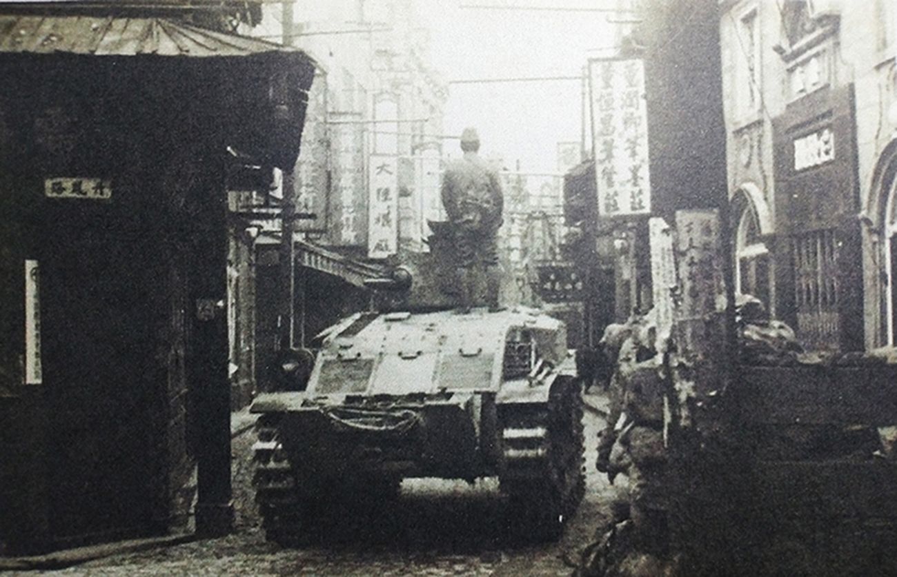 二战期间,在一座被日军侵占的城市里,一辆日军97式履带式骑兵装甲车正在一条狭窄街道上巡逻。