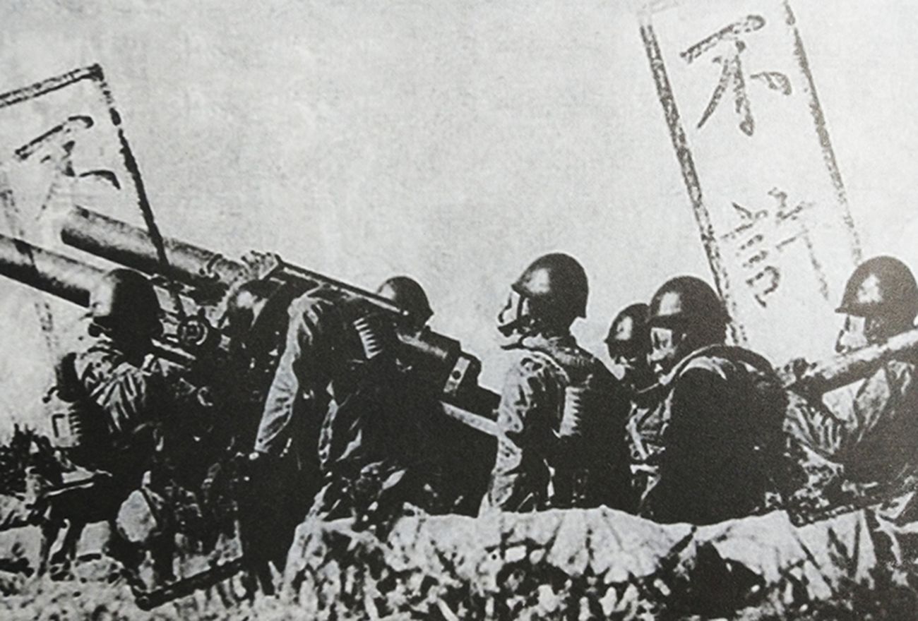 中国抗日战场上，侵华日军的1门150毫米野战榴弹炮正在向中国抗日军队的阵地发射毒气弹，其炮兵都戴上了防毒面具。注：为了隐瞒日军罪行，照片上打了不许发表的印章。