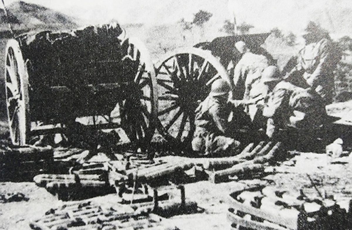 1933年，中国抗日战场，侵华日军的一门明治38式75毫米野炮正在向坚守长城的中国军队阵地开炮射击，火炮旁边是弹药车。