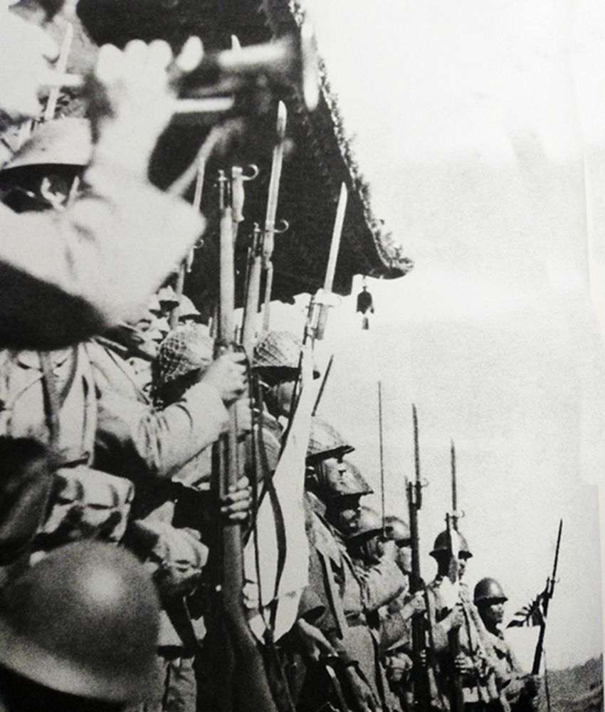 1937年9月,中国抗日战场,一群手持三八式步枪的日军士兵在刚占领的莱源城头上「欢呼」胜利。
