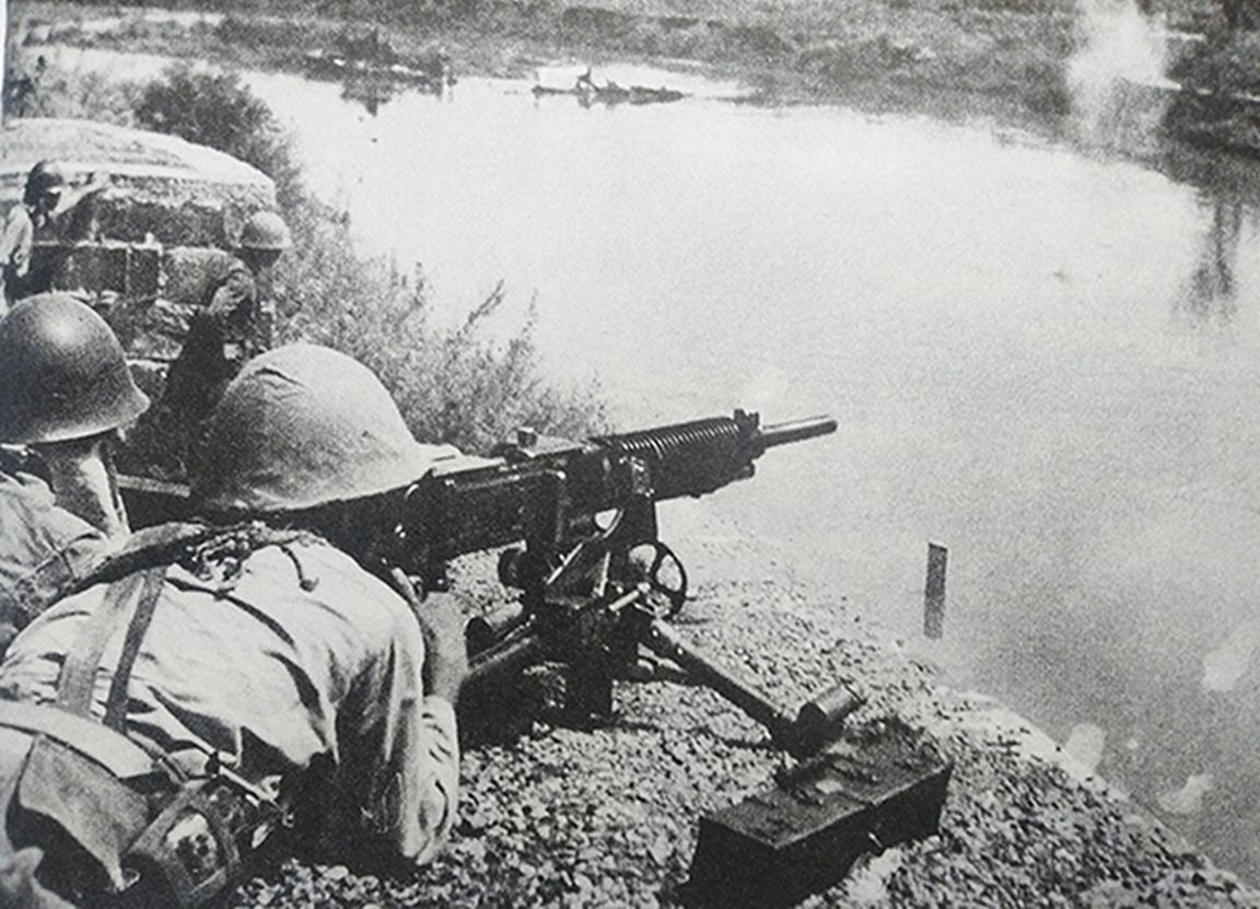 1941年9月,中国抗日战场,长沙会战期间,湖南省新市同乐桥地区,日军第4师团的一挺九二式重机枪正在向河对岸射击,压制中国抗日军队的火力点。