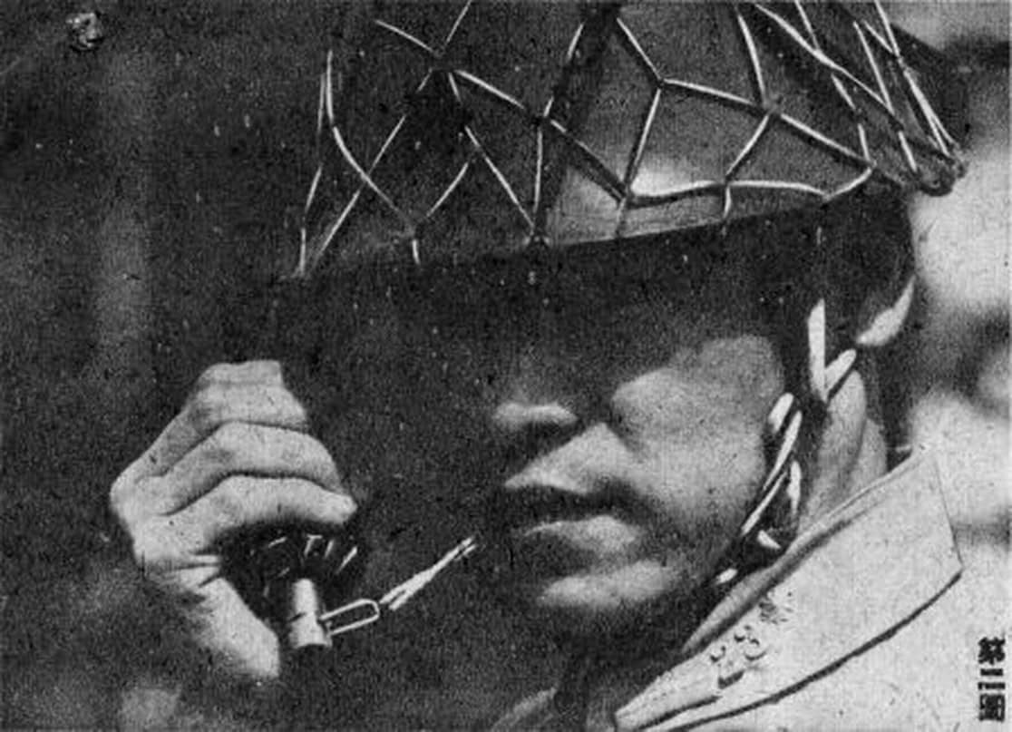 日军士兵用牙咬掉九七式手榴弹的保险销后，还需将弹帽在钢盔边缘用力磕击，以触发撞击引信点燃4-5秒延期药管。