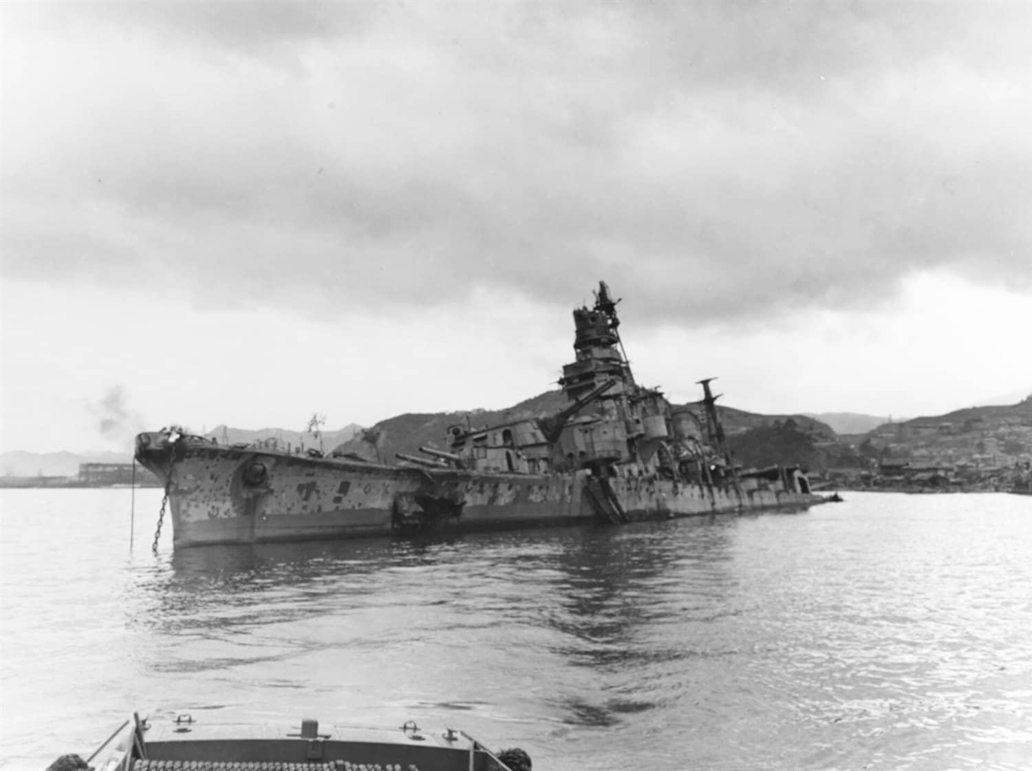 1945年10月9日，吴港内坐沉的青叶号残骸。该舰在1945年7月24日与28日的「吴港空袭」中被美军舰载机多次命中，舰首左舷可见7月24日空袭中500磅炸弹穿入前甲板造成的破洞。