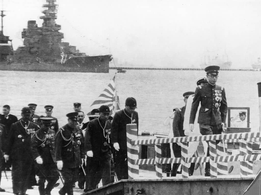 1940年,伪满洲国皇帝溥仪(康德)对日本进行国事访问。背景中所见即日本战列舰「日向」号。