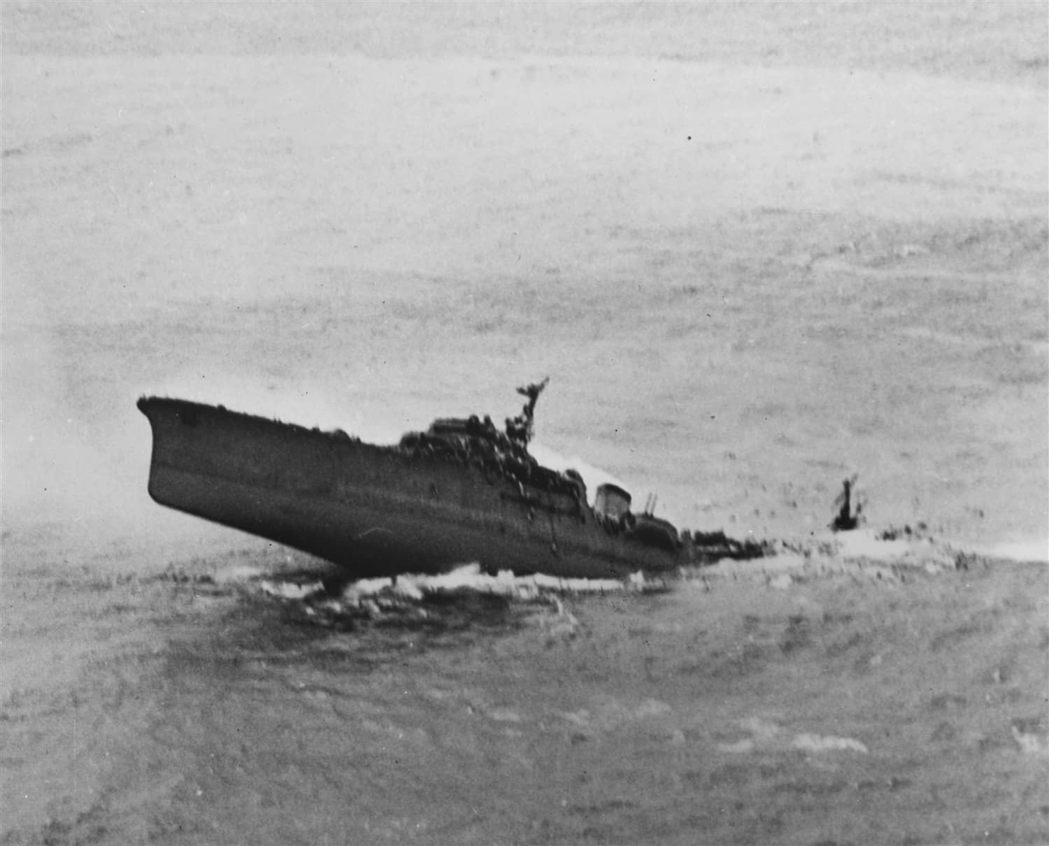1945年1月12日，「南中国海空袭」中，日本训练巡洋舰「香椎」号在法属印度支那近海遭美军航母舰载机攻击后沉没。画面摄自美军舰载机，可见该舰正在倾覆；香椎号当时担任「ヒ86」船团（HI-86）护航队旗舰。