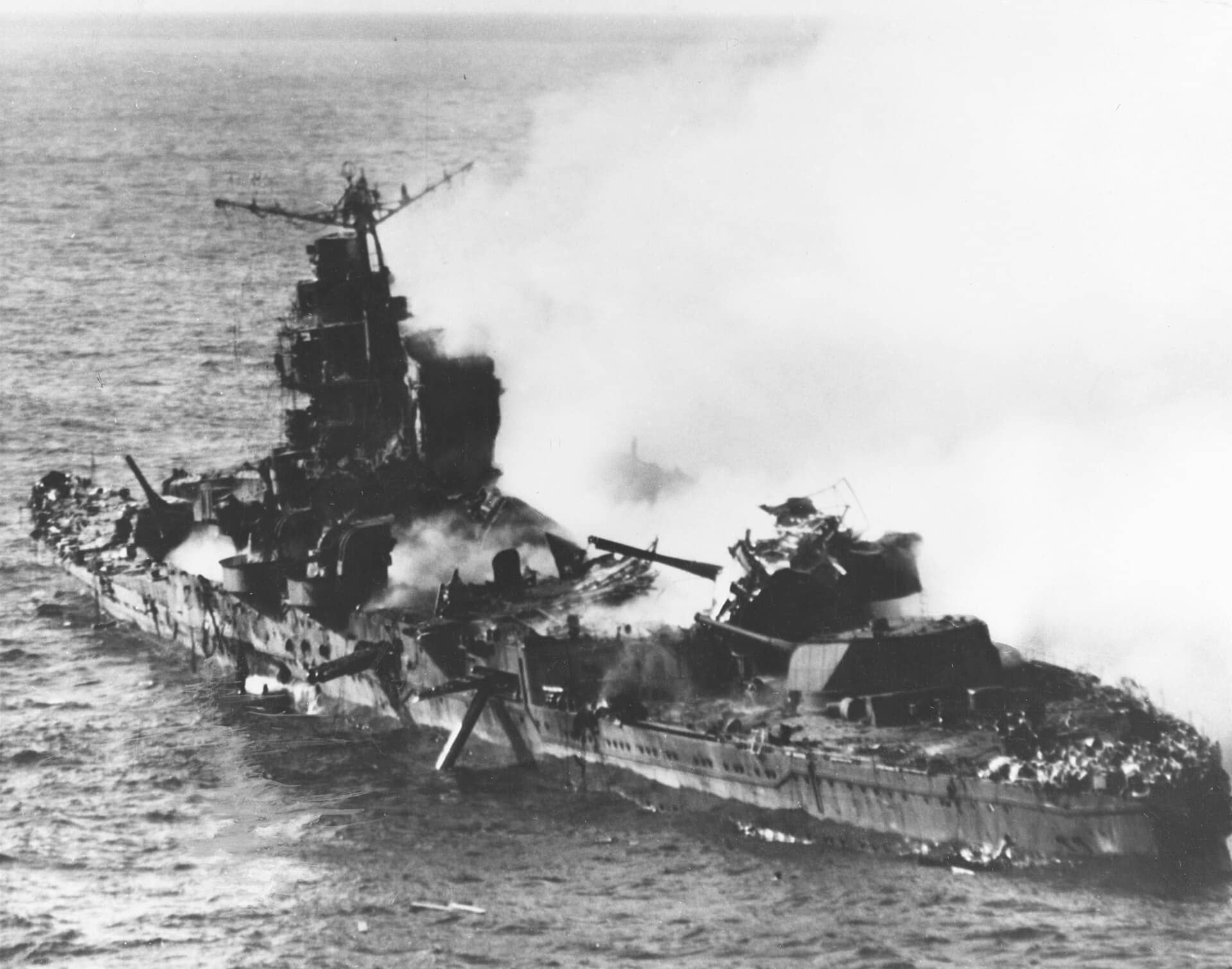 1942年6月6日，「中途岛海战」期间，燃烧下沉中的日本重巡洋舰「三隈」号，可见其中部结构被炸毁、鱼雷已诱爆。注：这幅照片是从美军「企业」号航母的道格拉斯SBD-3俯冲轰炸机上拍摄。