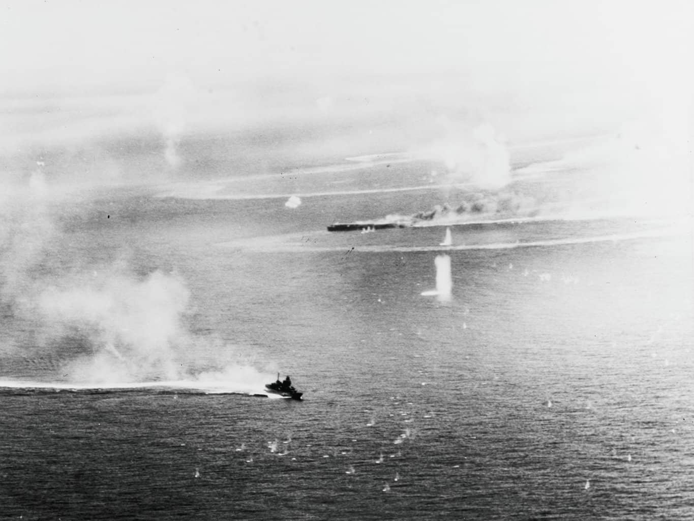 1944年10月25日,「恩加尼奥角海战」期间,轻型航母「瑞凤」号正在下沉,前景为高速机动规避炮火的日本轻巡洋舰「大淀」号。当日该舰身中炸弹仍坚持作战,接替沉没的「瑞鹤」号担任小泽舰队旗舰。