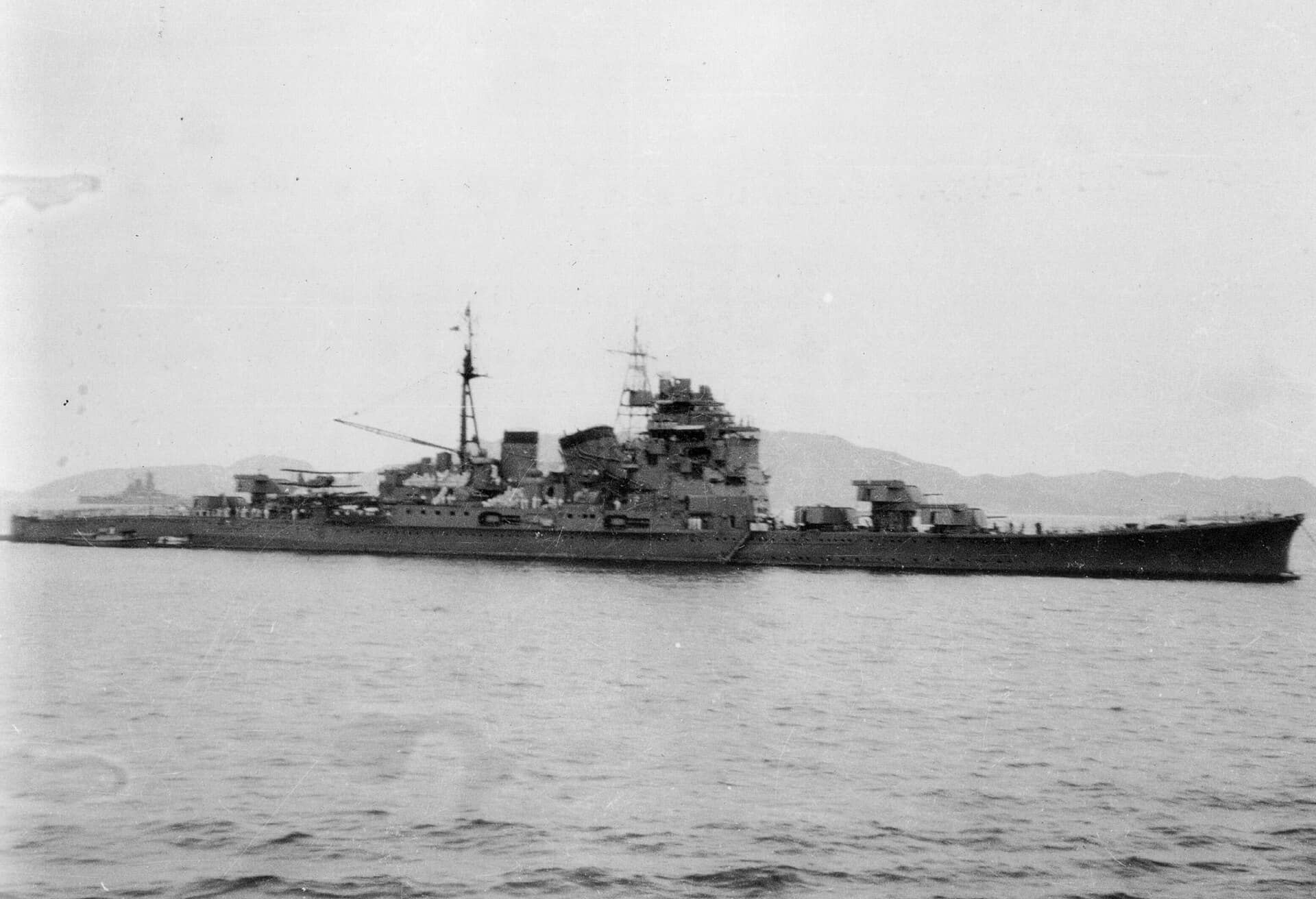 1942年11月20日，停泊于特鲁克（Truk）的鸟海号重巡洋舰。左侧背景隐约可见的是大和号（Yamato）战列舰。