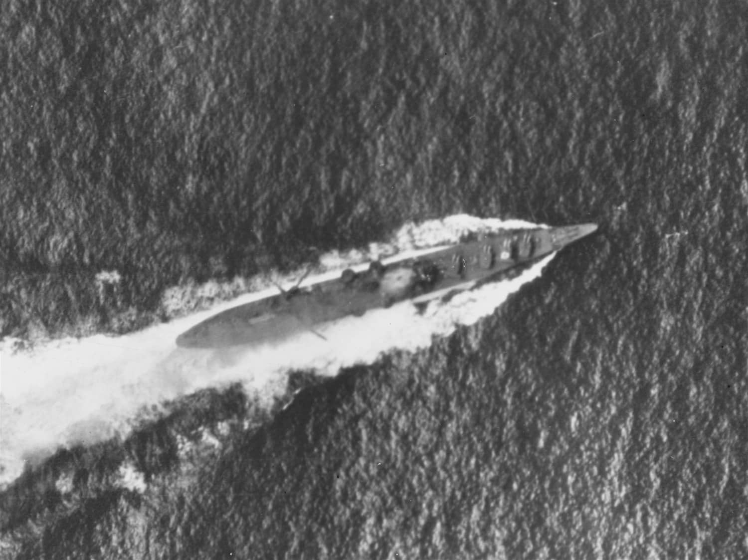 1942年10月26日，「圣克鲁斯群岛海战」中遭美军舰载机攻击的日本重巡洋舰「筑摩」号，舰桥区已被炸弹命中冒烟，二号主炮塔顶涂有白色识别标志，舯部弹射器与吊机已转出舷外。