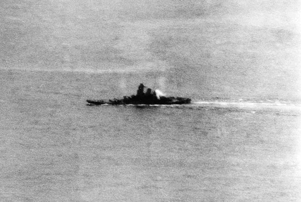 1945年4月7日,「坊之岬海战」期间,冲绳以北海域,遭受美国海军舰载机连续攻击的大和号战列舰已向左舷倾斜,上层建筑后部起火,但仍在继续航行中。这幅照片由约克城号(CV-10)航空母舰的飞机所拍摄。