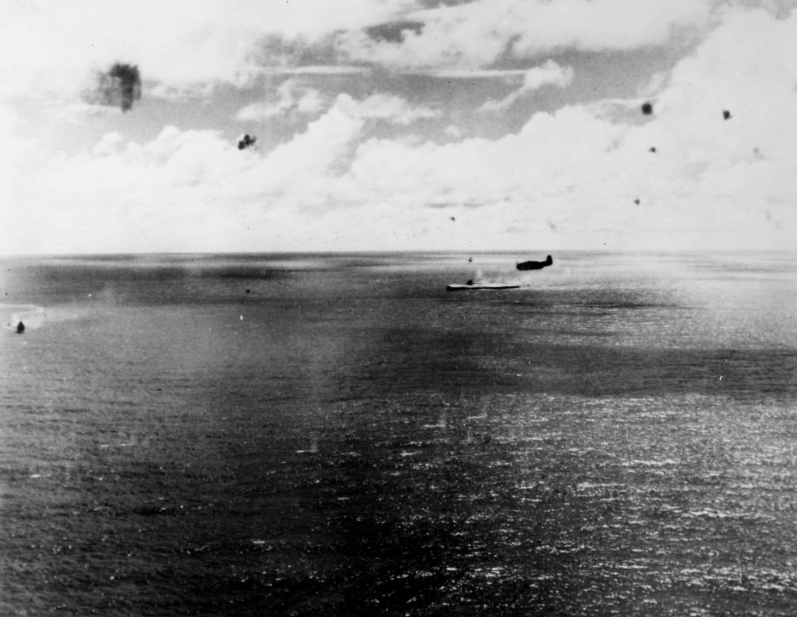 1944年10月25日,「恩加尼奥角海战」,瑞鹤号被盟军飞机命中后严重倾覆,航空母舰正在缓缓沉没,画面上方掠过的是美军TBF鱼雷机。