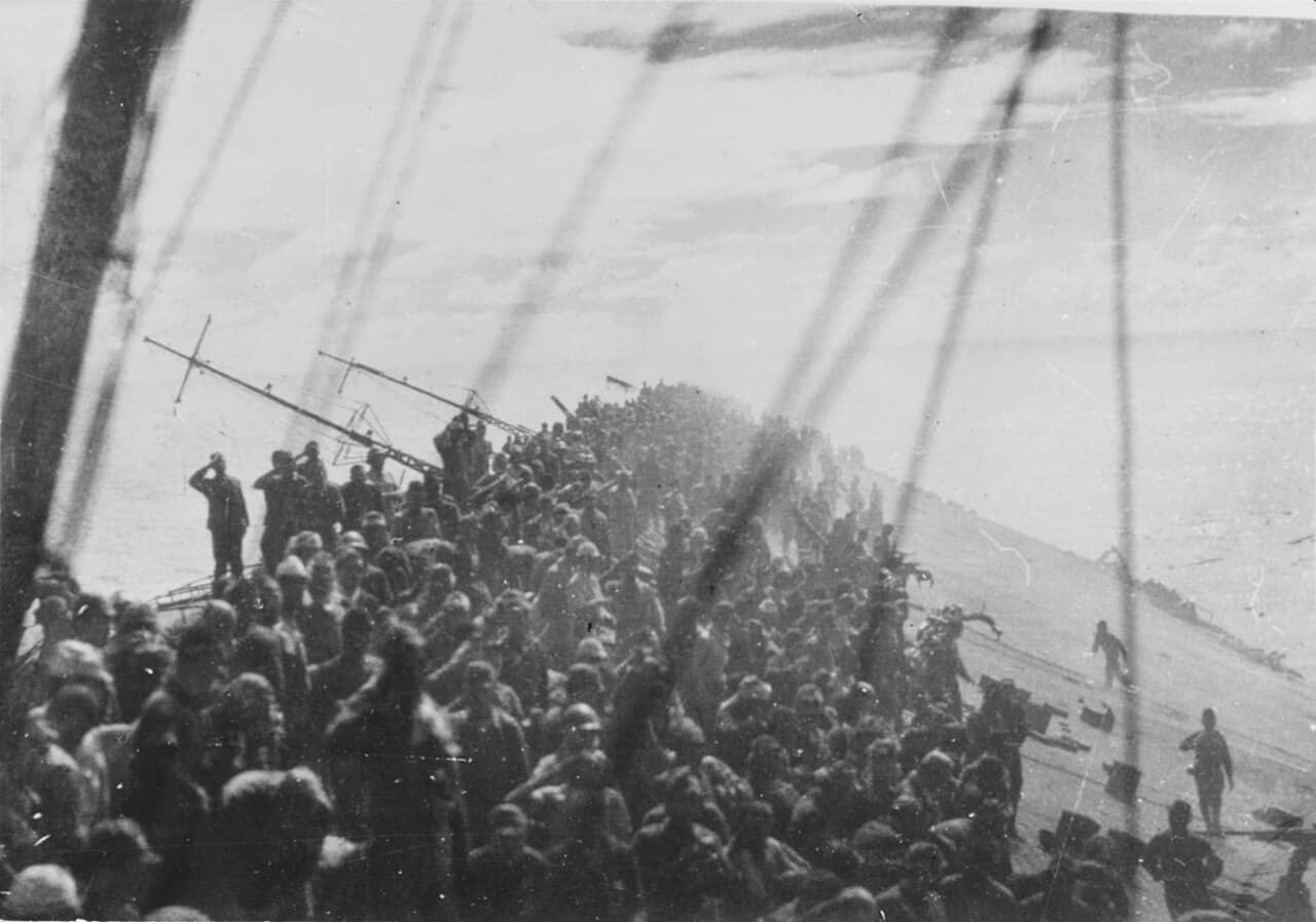 1944年10月25日,正在下沉的瑞鹤号航母舰员弃舰前向降下的军旗敬礼。可以看出此时的瑞鹤号已处于倾覆姿态。