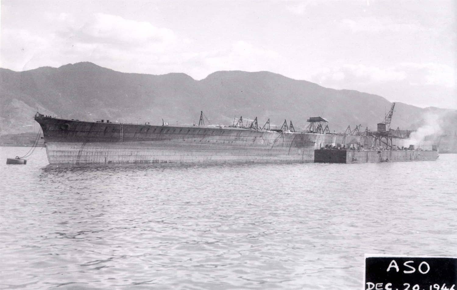 吴港内未完工的阿苏号(Aso)航空母舰。阿苏号为云龙级六号舰,1943年6月8日由吴海军工厂开工,1944年11月1日下水后因战局恶化于当日中止建造并停工漂浮于港内,1945年被当作实舰击靶目标,战后于1947年解体。