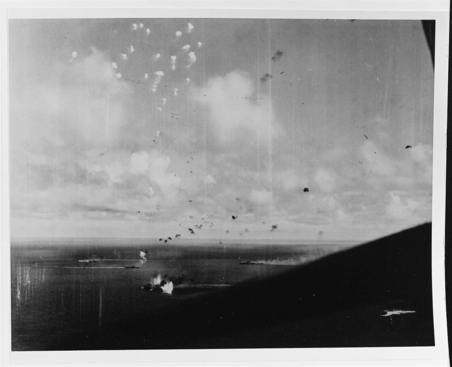 1944年10月25日,「恩加尼奥角海战」(莱特湾海战的一部分)中,日本舰队诱饵部队正遭美军第38特混舰队舰载机围攻。近景中可见瑞凤号轻型航母,远景处瑞鹤号正倾覆下沉,两艘驱逐舰正在赶赴救援。这场战斗成为日本海军航母部队的最终覆灭。