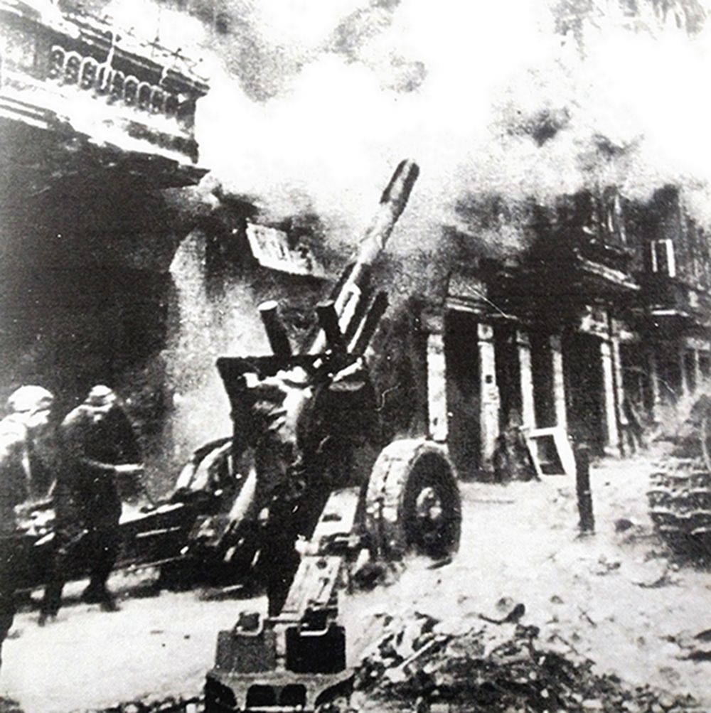 1945年，「布达佩斯战役」期间，东线战场，匈牙利首都布达佩斯的攻防战进入了巷战阶段，一门1937式152毫米榴弹炮被苏军推入城中街道，向德军防守阵地猛烈开炮。