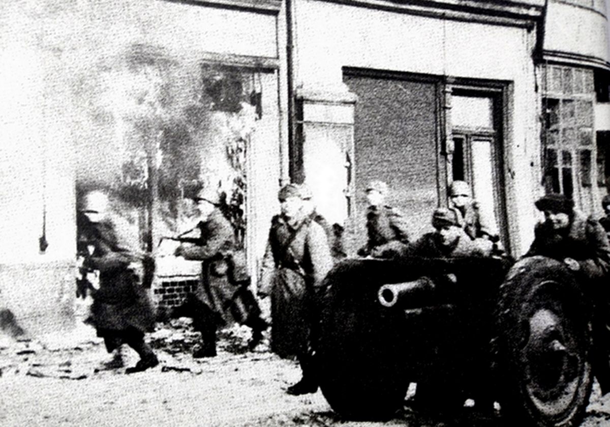 1945年春，「苏德战争」期间，东线战场德国某城镇内，苏军一门1927式76毫米步兵炮正在掩护步兵向前推进。