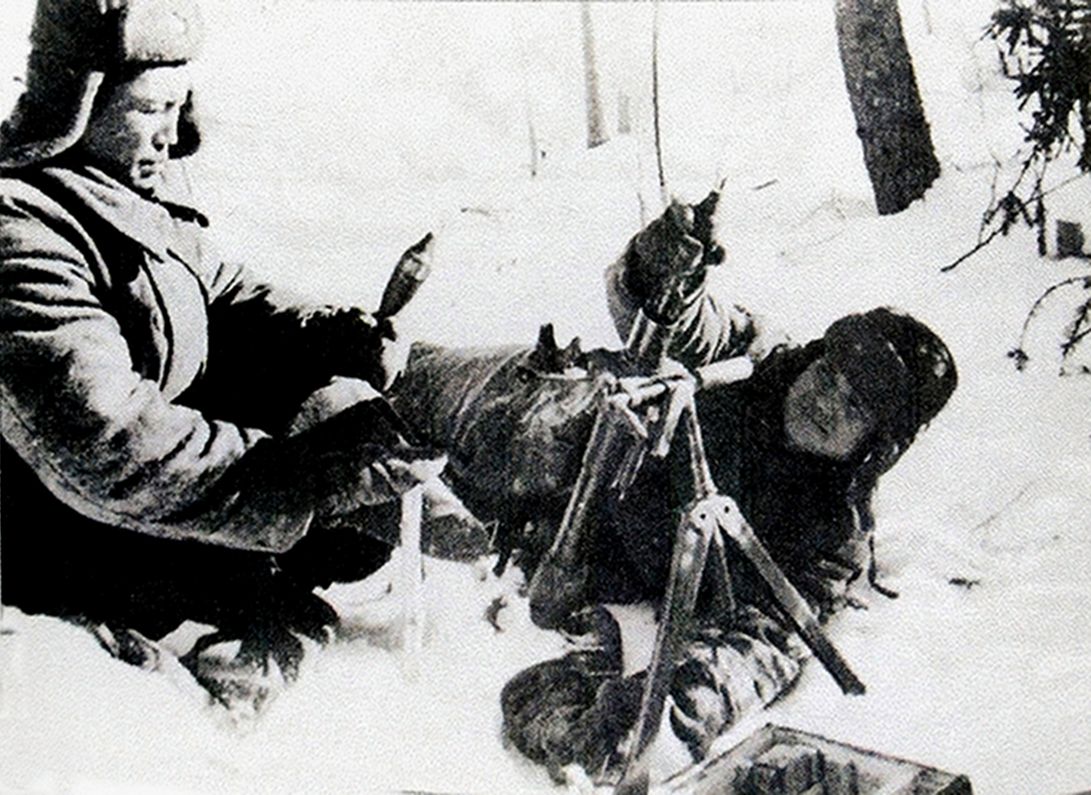 1941年冬季，「苏德战争」期间，东线苏联战场，两名苏军士兵正在雪地上为一门1941式50毫米迫击炮装弹发射。50毫米迫击炮是苏军步兵连的标配，每连有2个迫击炮排，每排配备两门迫击炮，主要为所属连队提供火力支援。