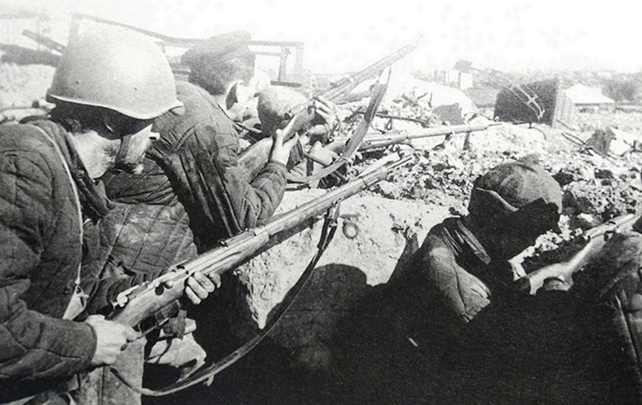 1942年10月，「斯大林格勒保卫战」期间，东线苏联战场，工人民兵营的战士手持「莫辛-纳甘」1891/30式步枪坚守在一处废墟阵地上。