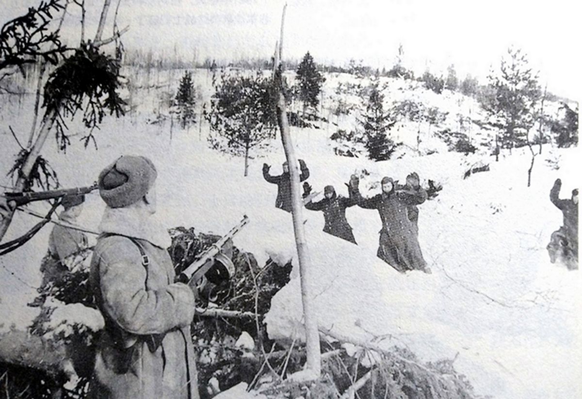 1941年~1942年冬天,「莫斯科保卫战」期间,东线苏联战场,雪地中一群向苏军投降的德军士兵,一名手持PPSh-41型冲锋枪的冲锋枪手正警惕地注视着走来的德军俘虏。