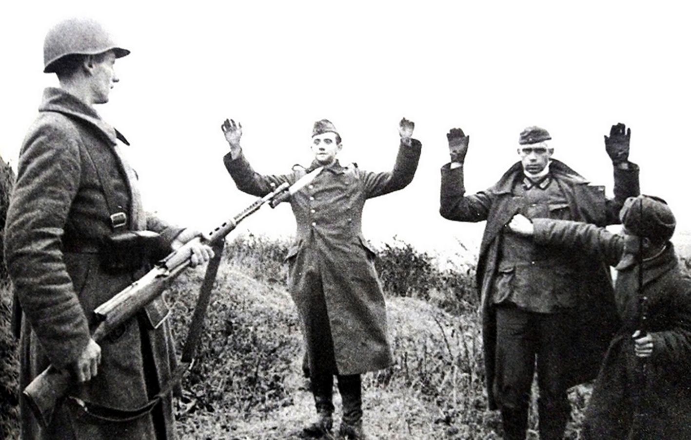 二战东线苏联战场,两名德军士兵在手持SVT-40半自动步枪的苏军战士面前举手投降。