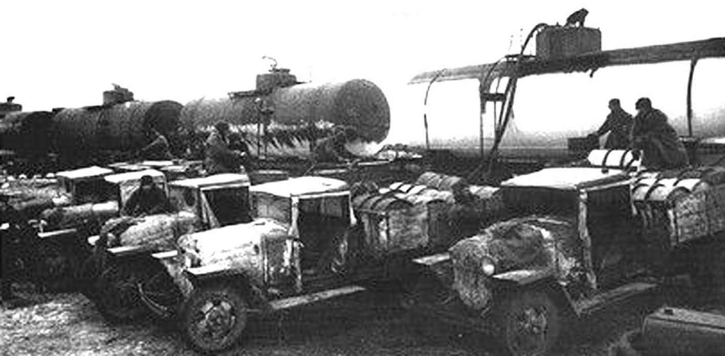 一队嘎斯 GAZ-MM（1941）军用卡车正在车站装载火车运来的罐装油料。该型车性能与嘎斯（GAZ-AA）基本相同，虽车重稍大一些（1.81吨），但仍属轻型卡车。