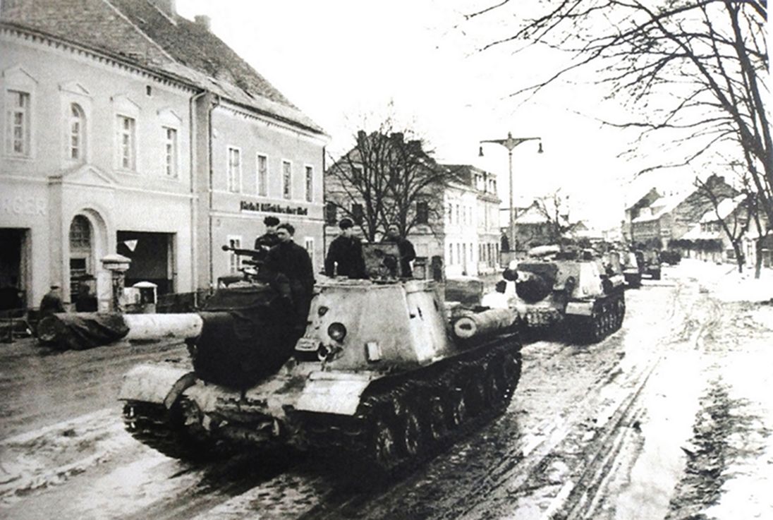 1945年4月，「苏德战争」期间，一支进入德国的苏军ISU-122型自行炮车部队正行驶在一德国城镇大街上。