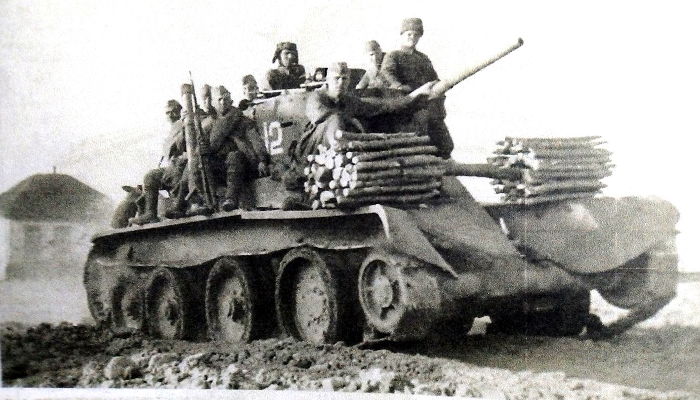 1942年5月,「苏德战争」期间,苏联东乌克兰前线,一辆隶属于苏军西南方面军第57装甲旅的BT-5快速坦克正搭载士兵前往进攻集结地。坦克上搭载的木棍是用来填平前进道路遇到的反坦克沟壕或作泥泞路上铺垫用。