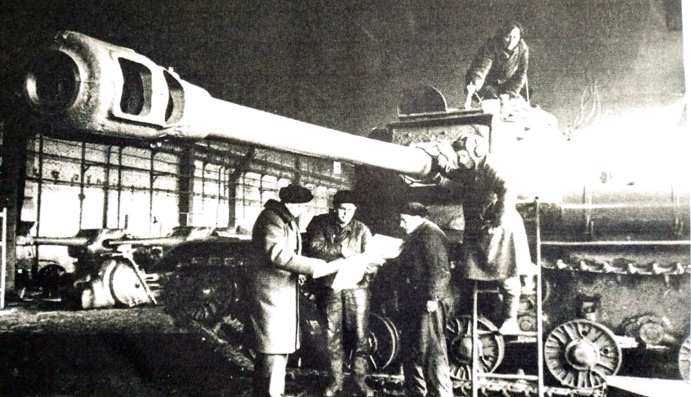 1945年，「苏德战争」期间，位于苏联车里雅宾斯克的基洛夫工厂中，军代表与技术人员正对一辆IS-2重型坦克进行验收，注意：122毫米火炮身管很长，前端是火炮制退器。