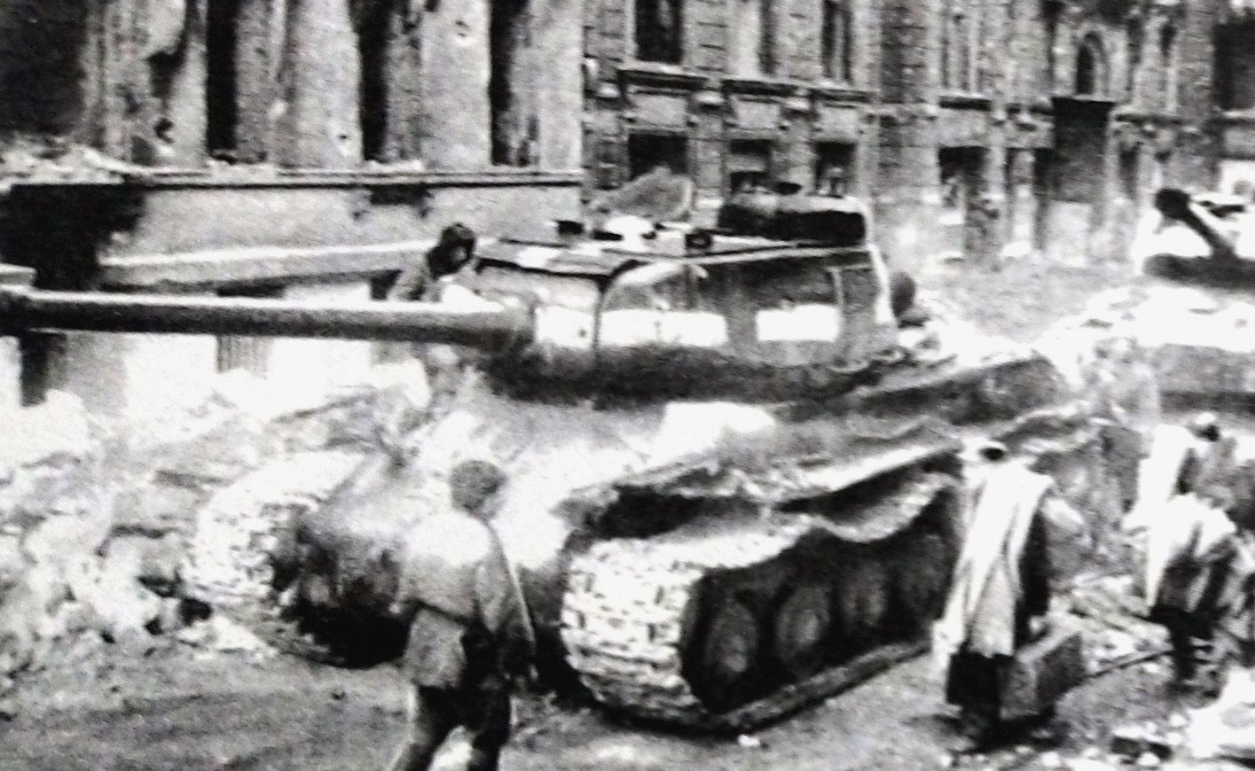 1945年4月，「柏林战役」期间，一辆攻入柏林的苏联白俄罗斯第一方面军的IS-2重型坦克停靠在路边。在坦克旁边的是一群刚从地下室出来的柏林难民。