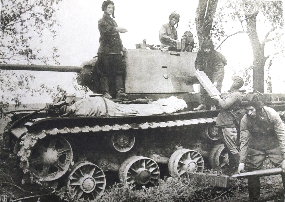 1942年夏季,「苏德战争」期间,东线苏联战场,一辆KV-1坦克乘员在一名军官指挥下装填弹药。注意:那些长方形盒子是用来装炮弹的。