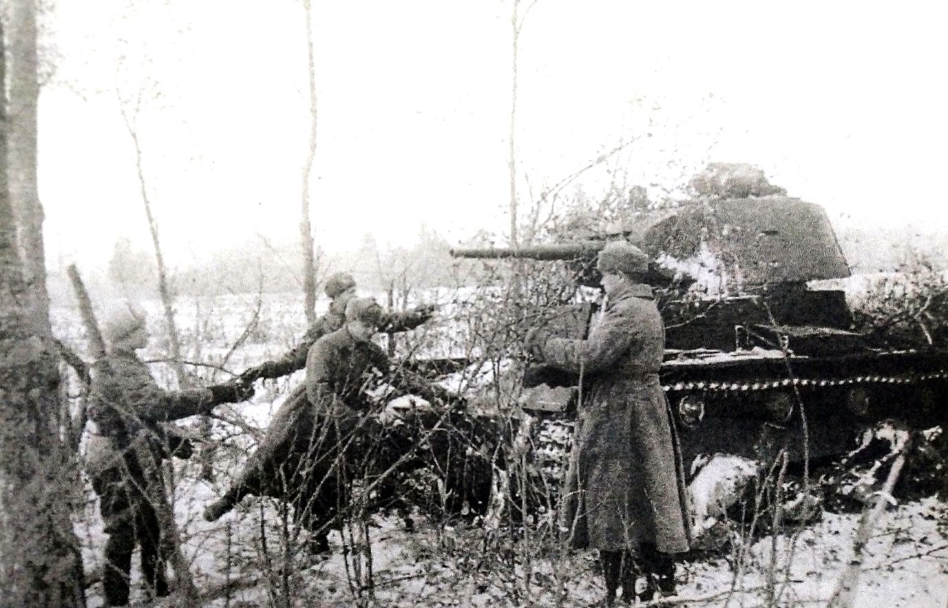 1941年11月，「苏德战争」期间，苏联西部战场，几个苏军士兵用树枝在给一辆T-26轻型坦克作掩护，应该是为了防止德军飞机的空袭。